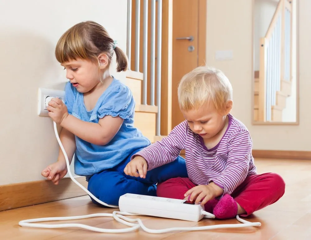 Children playing with outlet and power strip