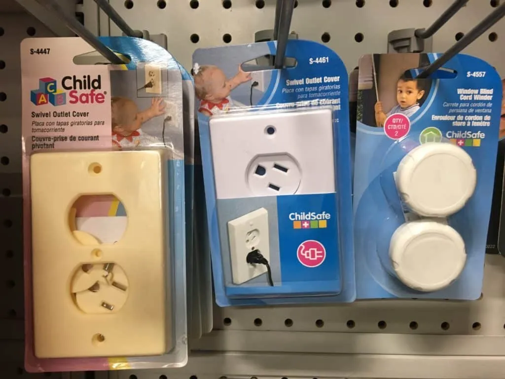 Child safety outlet covers displayed in retail packaging on a store shelf.