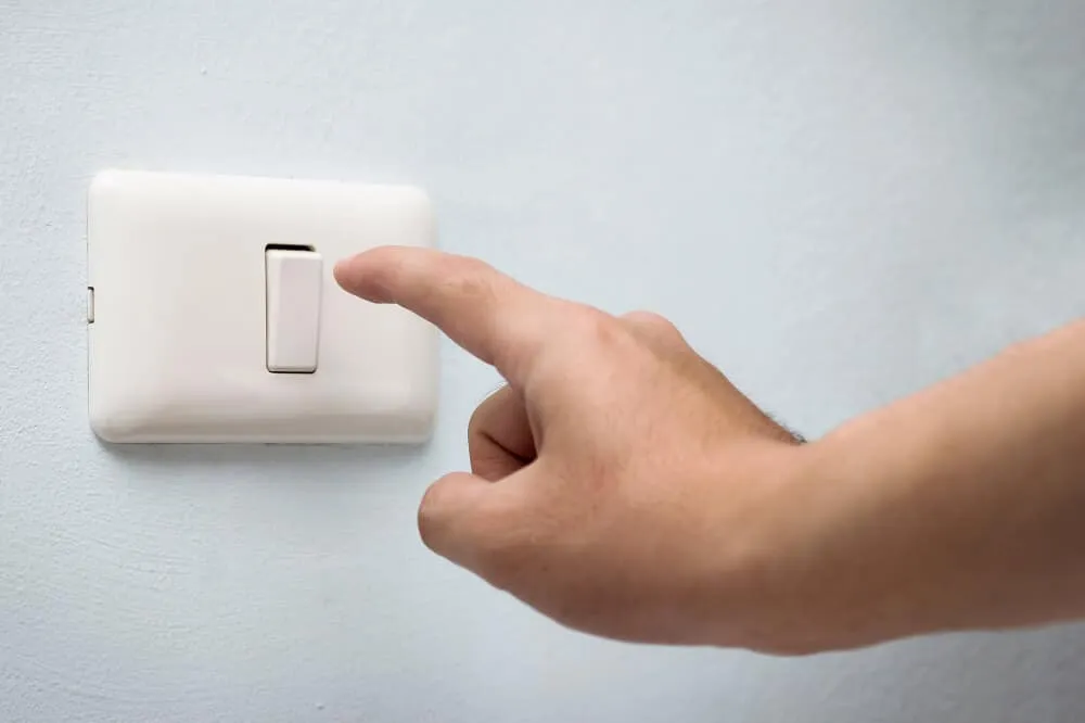Finger pointing at light switch